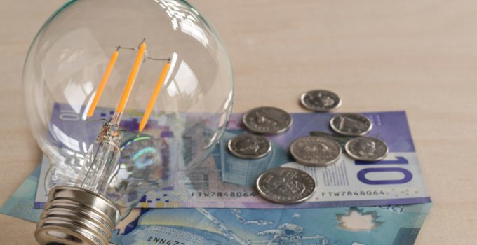 LED light bulb with canadian dollars paper money and coins, energy saving concept
