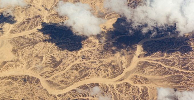 Clouds over a desert landscape. View from the airplane window