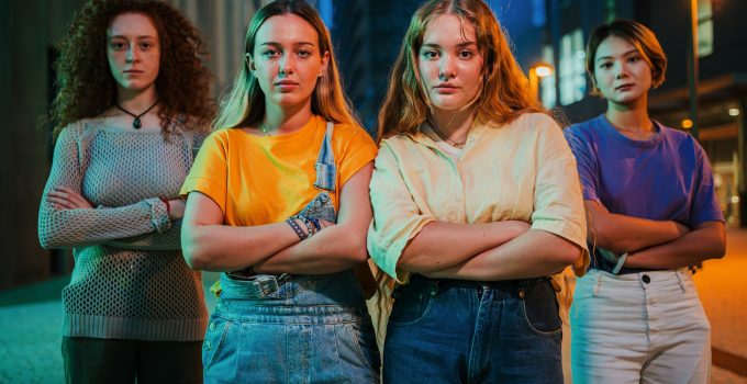 Portrait of a group of serious young women looking at camera together at night time. Proud feminine