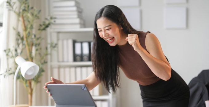 Businesswoman feeling happy about good news received on digital tablet