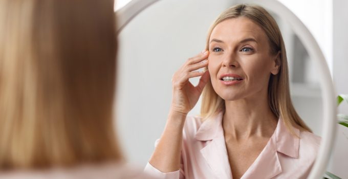 Closeup Shot Of Middle Aged Beautiful Woman Looking In Mirror At Home