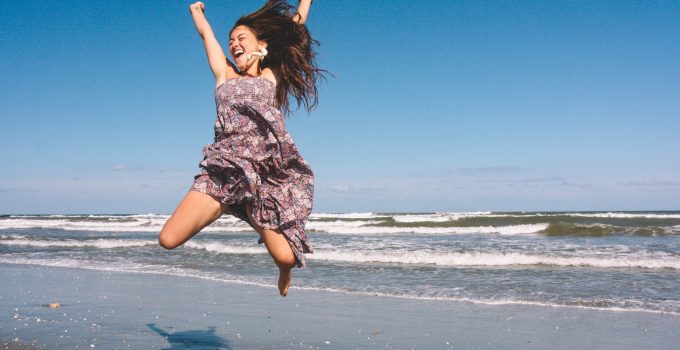 Woman jumping with joy on a beach.
