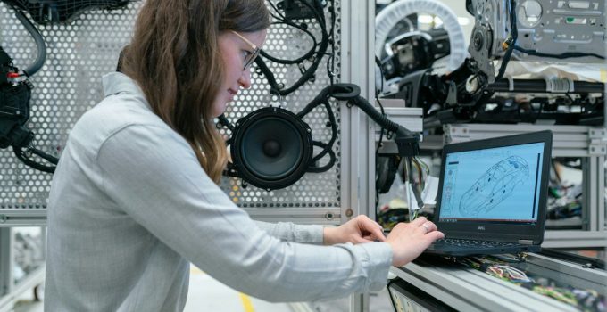 woman in white long sleeve shirt using black laptop computer