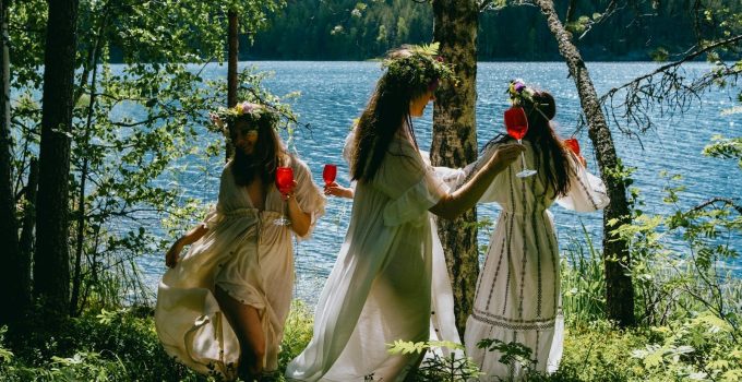 A group of women standing next to each other near a lake