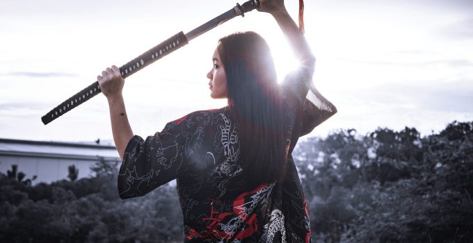 a woman holding a sword in her hands