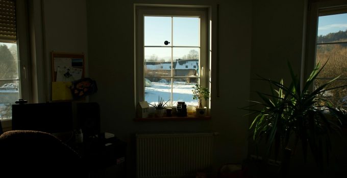 Sunlight streams through a window onto snow-covered landscape